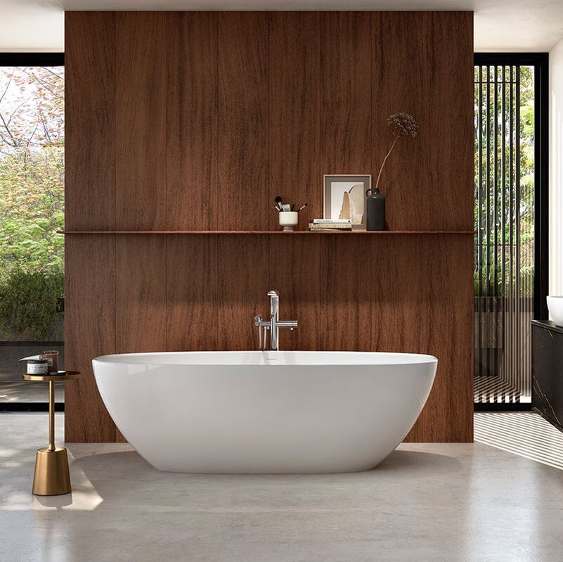 Midcentury modern bathroom with a stone victoria and albert barcelona bathtub in front of a walnut panel wall