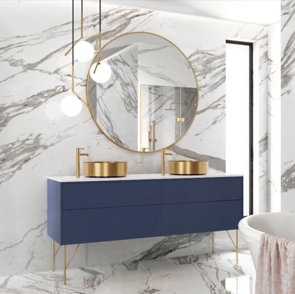 modern bathroom with gold vessel faucets and steel sinks on a blue vanity and mid century modern pendants with a round gold mirror and marble walls