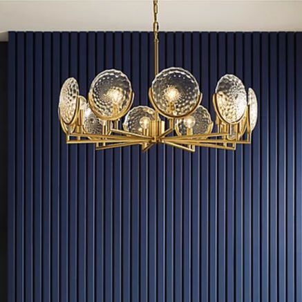 Gold and glass chandelier by Kohler lightingwith a blue wall