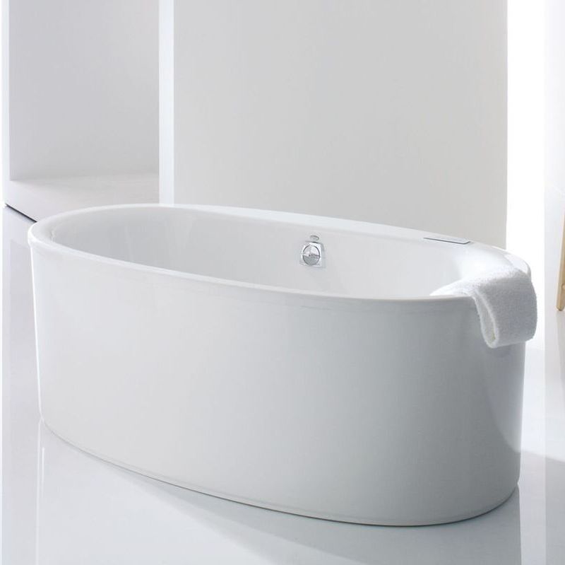 Acrylic freestanding white bathtub in a stark white room