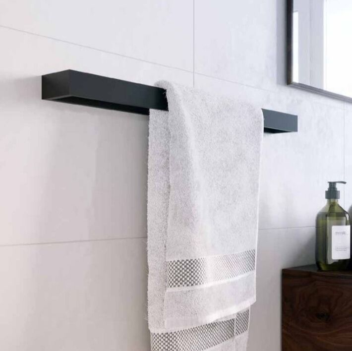 Modern square matte black ICO towel bar on a tile wall with towel and rectangular mirror
