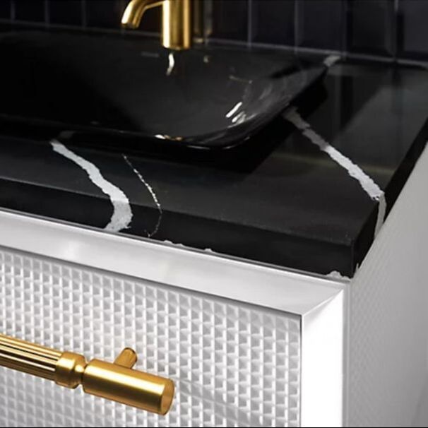 closeup Kohler Envivo wall hung vanity in white with modern brushed brass hardware and a black and white silestone countertop black vessel sink and brushed gold kohler faucet 