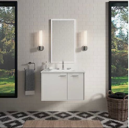 Wallmounted kohler jute vanity in white with modern led mirror and two kohler purist sconces on a subway tile wall