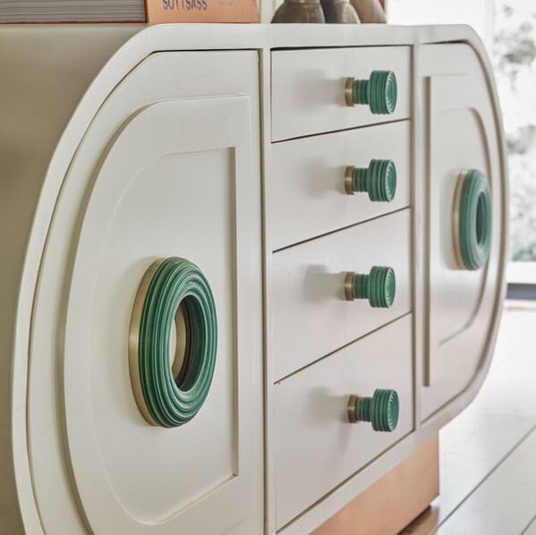 Unique green ceramic cabinet knobs and pulls on a white mid-century modern sideboard