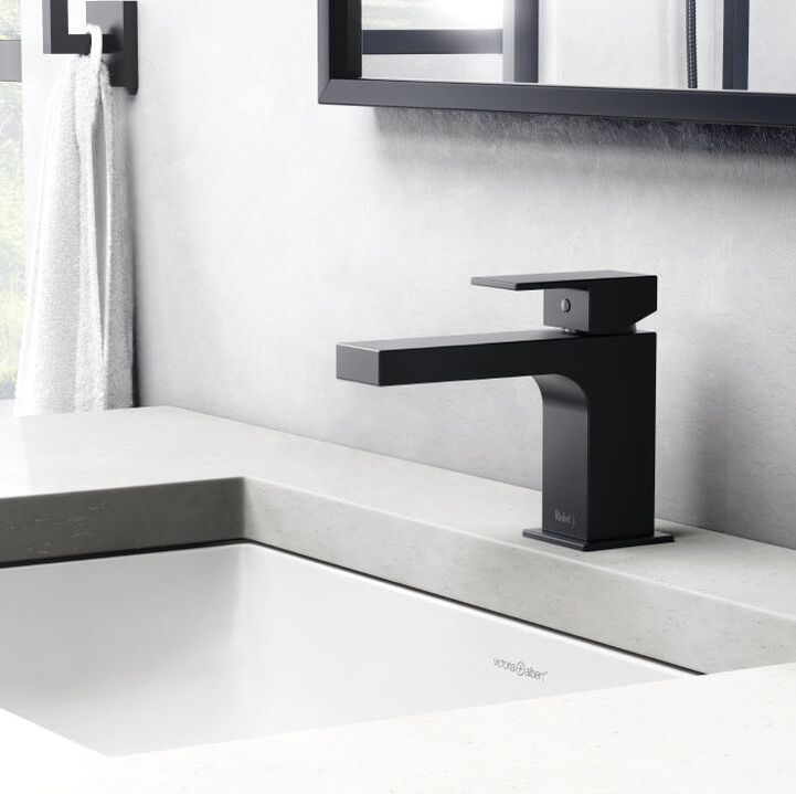 Riobel Pro matte black square single hole bathroom sink faucet from their quadrik collection and white rectangular andermount sink and matte black framed mirror
