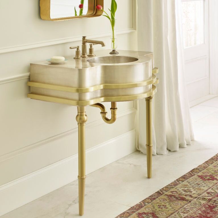 Thompson Traders gold bathroom sink in an art deco style with floor to ceiling drapery 
