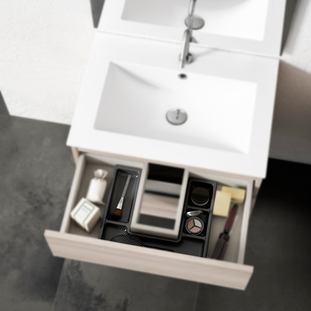 ICO seamless one-piece countertop on a white oak vanity with an open drawer showing an ico drawer organizer full of bathroom accessories above a dark concrete floor and white wall