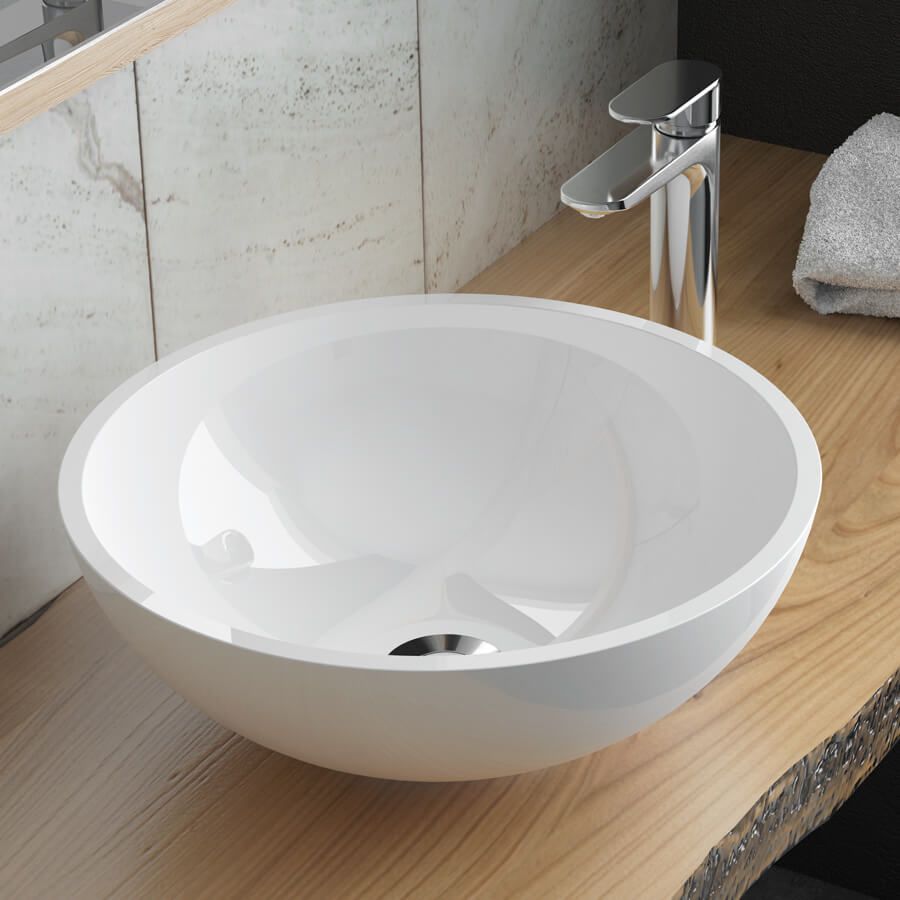 Gloss white vessel bowl sink in gloss white on a wooden countertop in front of marble tiles