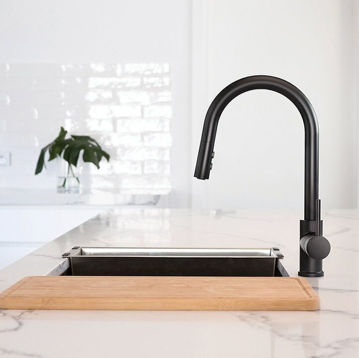 Riobel Pro matte black Njoy single hole kitchen sink faucet with a workstation sink in an all white kitchen and marble quartz countertop