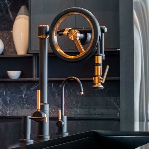 Waterstone Endeavor Wheel Black and bronze kitchen faucet with matching soap dispenser and filtered water faucetand knurled accents in polished nickel and marble countertop and backsplash 