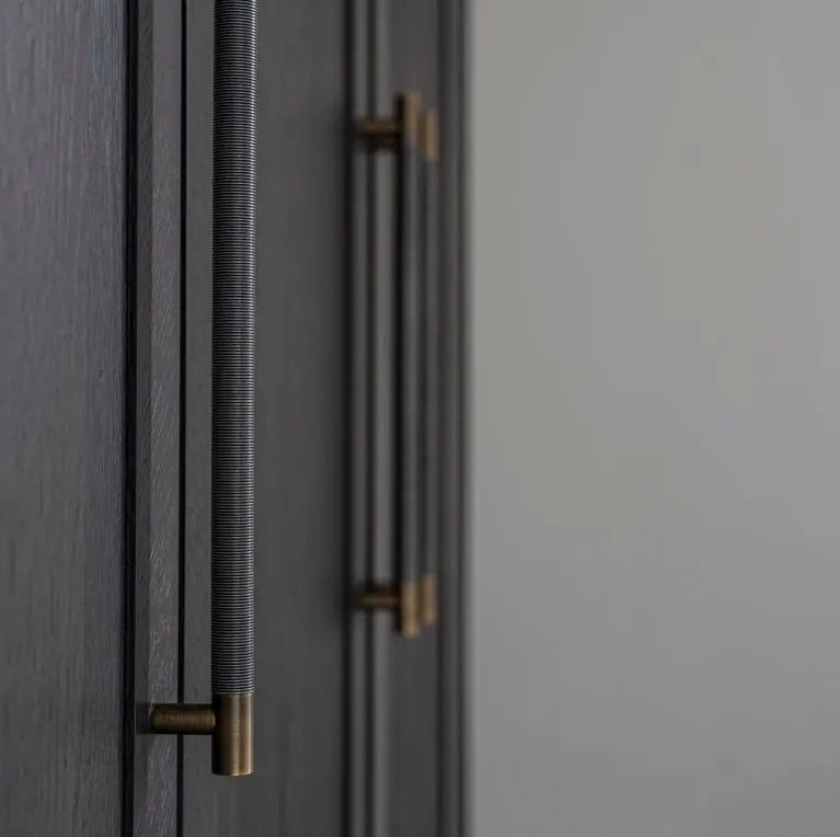 Turnstyle Designs bar pull luxury cabinet hardware on dark grey cabinet